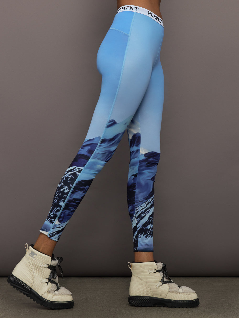 Side profile of Printed Base Layer Leggings in Ski Lift Blue showing mountain print detail.