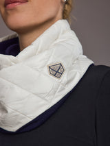 Close-up of a white quilted neck warmer with a brand logo on a neutral background