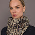 Woman wearing a leopard print scarf against a gray background
