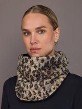 Woman wearing a leopard print scarf against a gray background