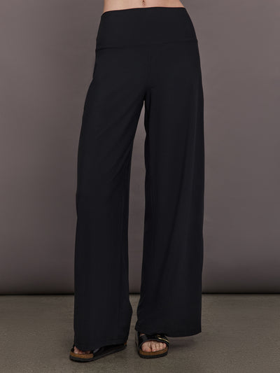Model is wearing Palazzo Pant in Melt in black, front full length view with wide leg silhouette and high rise waistband.