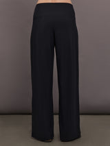 Model is wearing Palazzo Pant in Melt in black, back view showcasing wide leg shape and clean waistband construction.