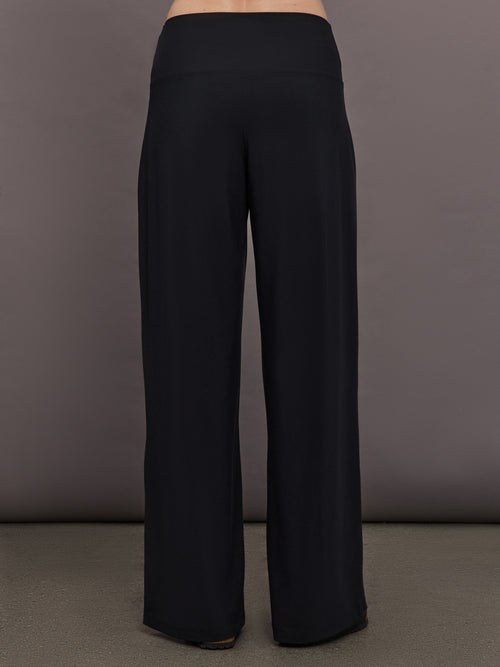 Model is wearing Palazzo Pant in Melt in black, back view showcasing wide leg shape and clean waistband construction.