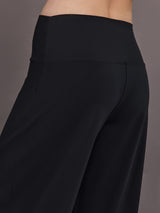 Model is wearing Palazzo Pant in Melt in black, angled back close-up of waistband and seam detailing.