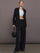 Model is wearing Palazzo Pant in Melt in black, styled with black blazer and cropped top for elevated look.