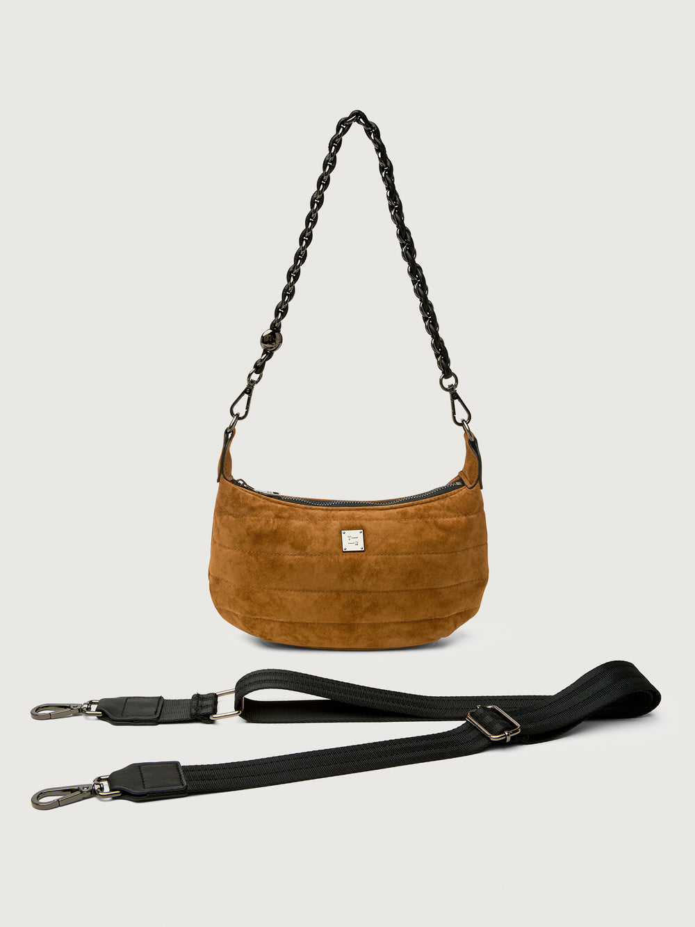 Brown suede handbag with a black strap on a light gray background