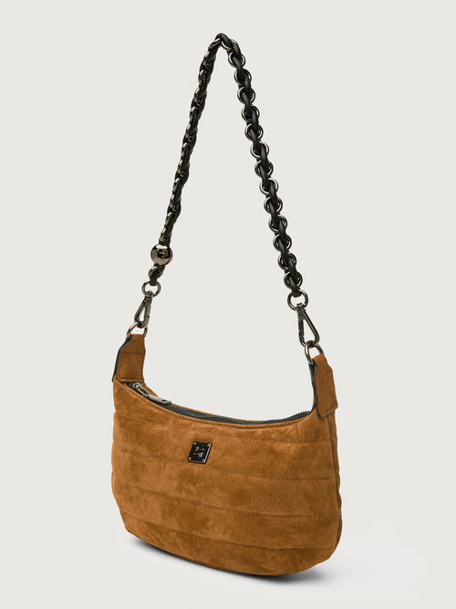 Brown suede handbag with a braided black strap on a light gray background