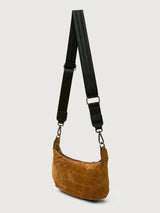 Brown suede handbag with a black strap on a light gray background