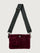 Burgundy suede handbag with a black seat belt strap 