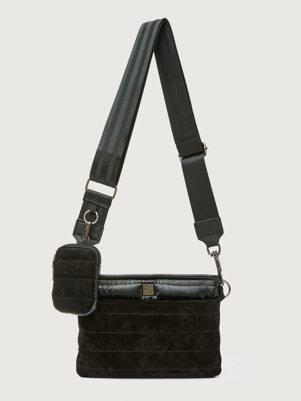 Black quilted crossbody bag with a strap on a light gray background