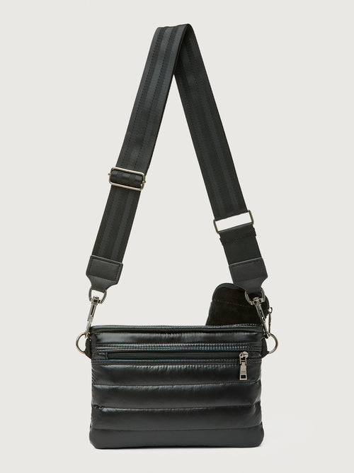 Black leather crossbody bag with a strap on a light gray background