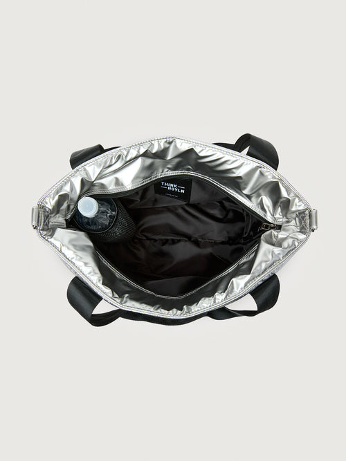 Silver insulated tote bag with black handles on a light gray background