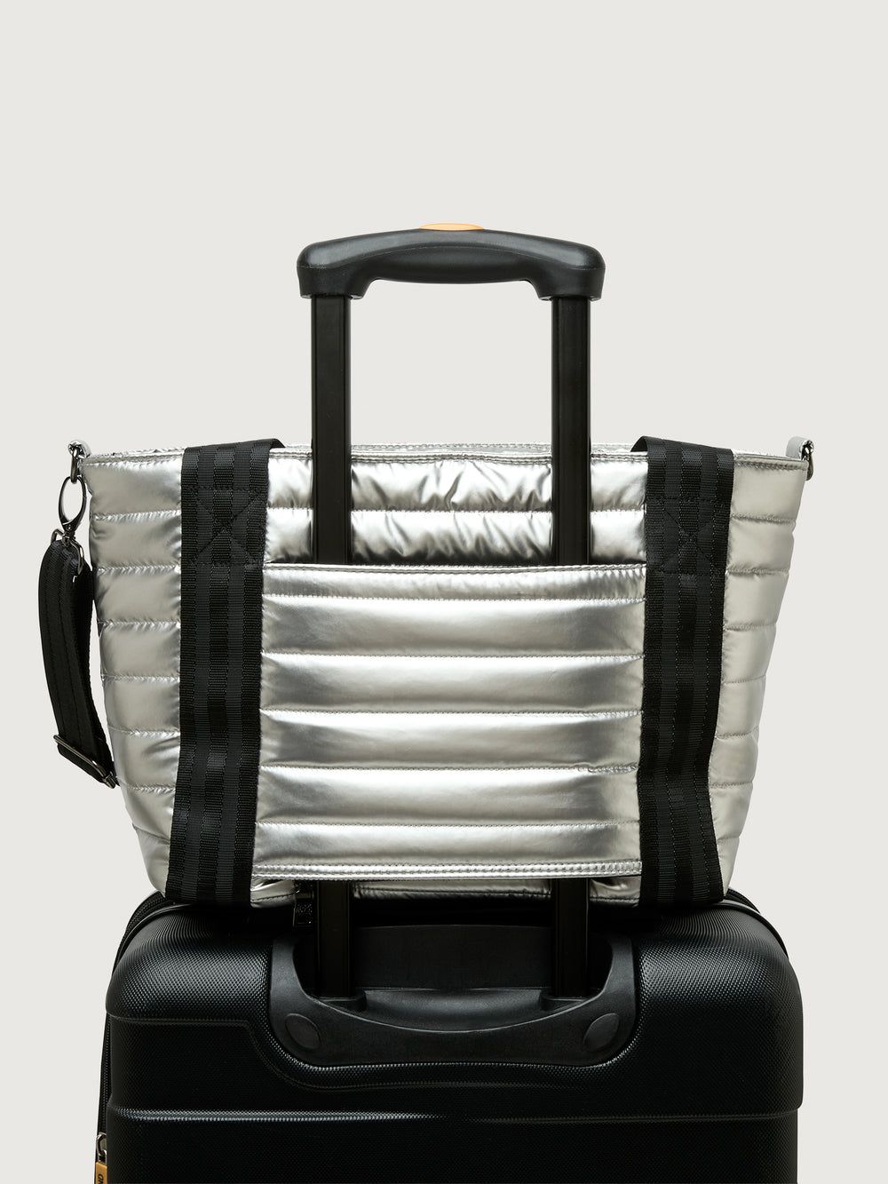 Silver insulated tote bag with black handles on a light gray background