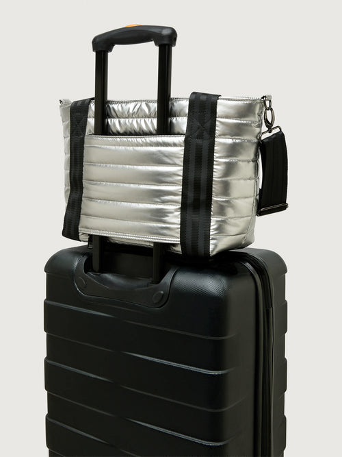 Silver insulated tote bag with black handles on a light gray background