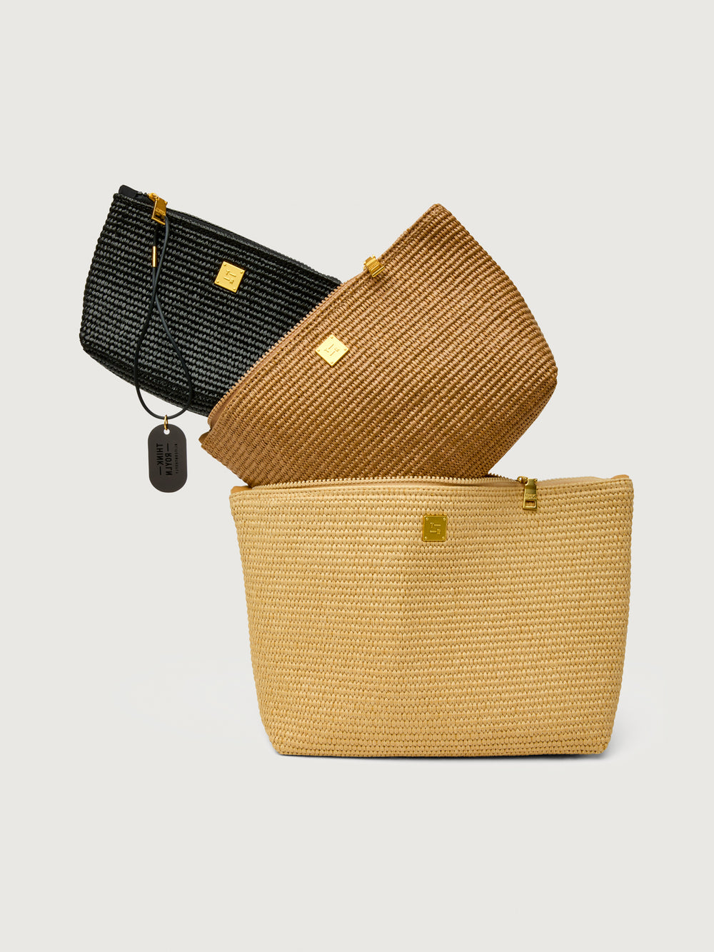 Travel Trio in Dune Raffia, overlapping pouches front view.