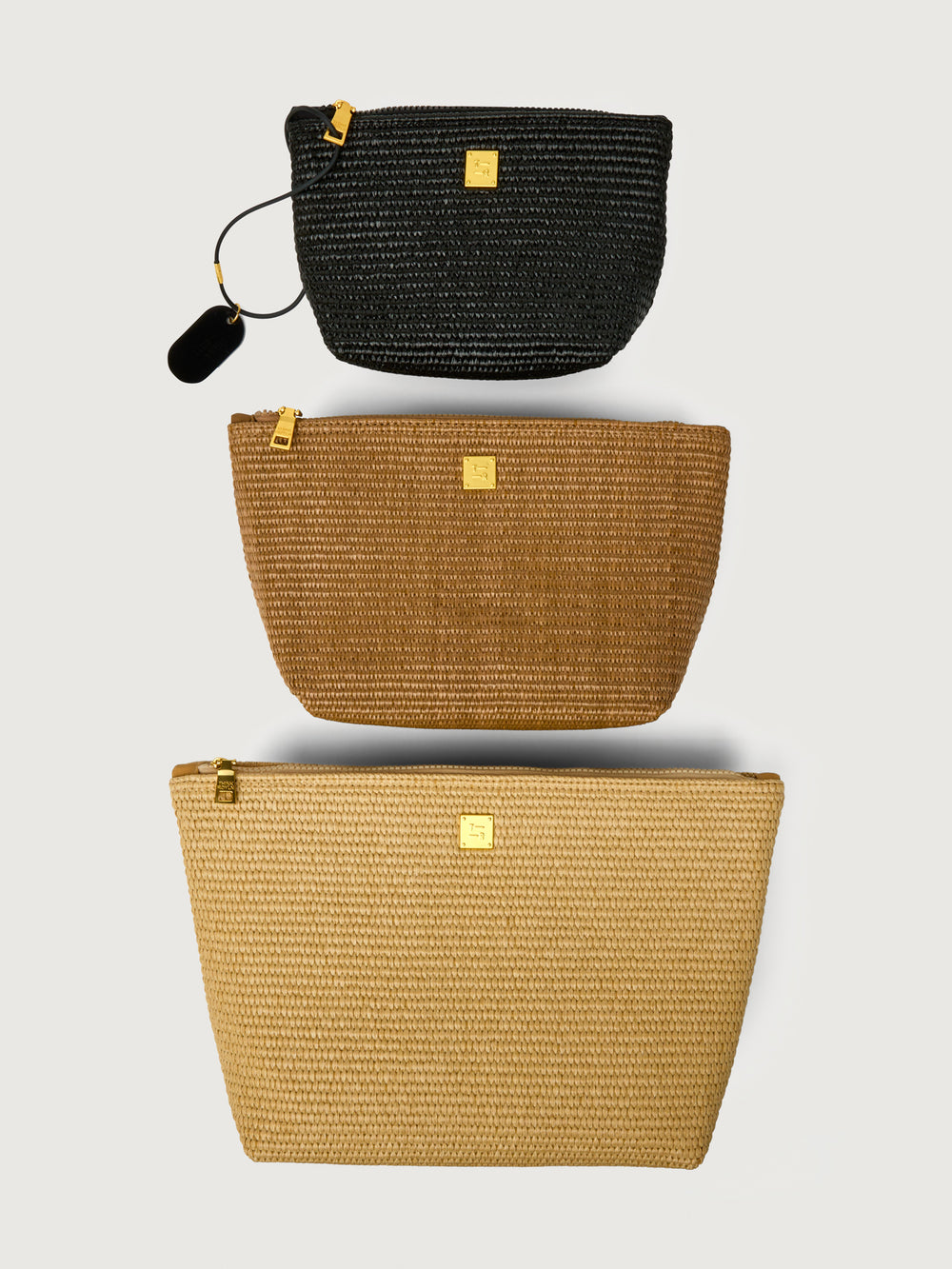 Travel Trio in Dune Raffia, three pouches stacked front view.