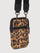 Angled back view of leopard print crossbody bag with zipper pocket and hardware rings.