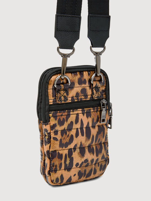 Angled back view of leopard print crossbody bag with zipper pocket and hardware rings.