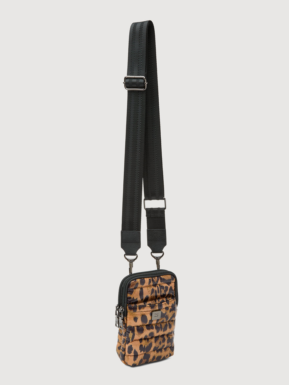 Angled front view of leopard print puffer crossbody bag with adjustable strap and silver hardware.