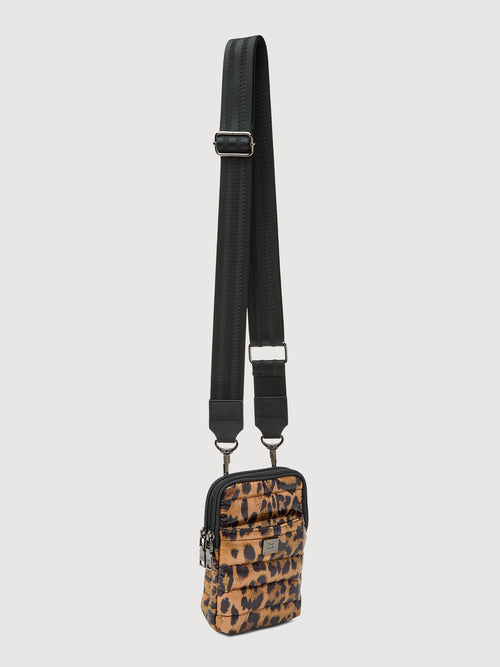 Angled front view of leopard print puffer crossbody bag with adjustable strap and silver hardware.