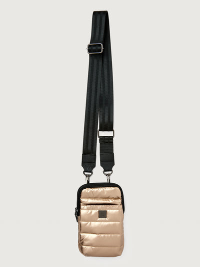 Gold crossbody bag with a black strap on a light gray background