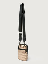 Gold crossbody bag with a black strap on a light gray background