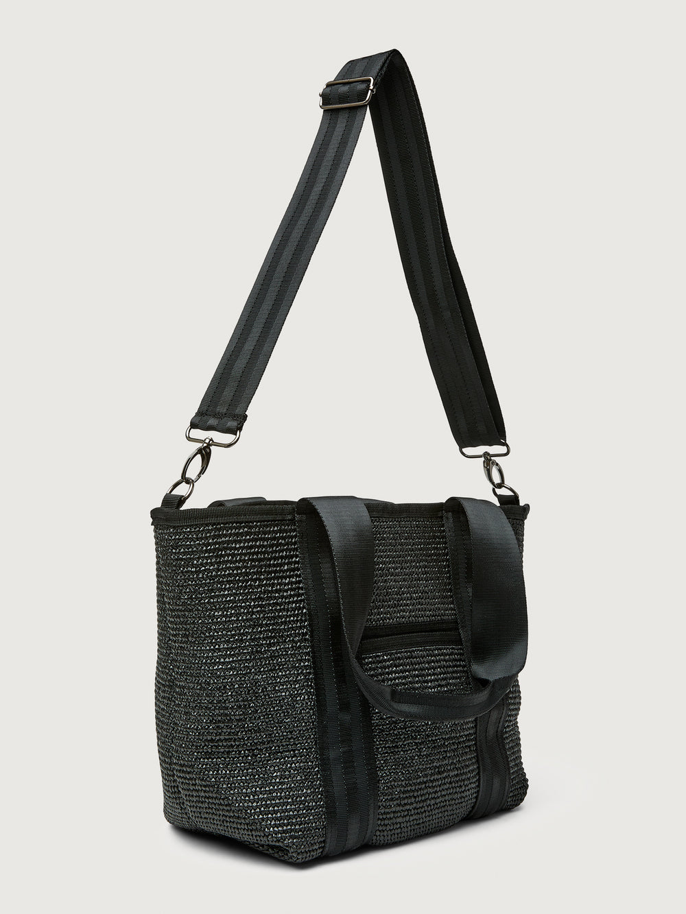 Side angle of Think Royln Capri black tote with adjustable crossbody strap and short top handles.