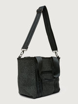 Side angle of Think Royln Capri black tote with adjustable crossbody strap and short top handles.