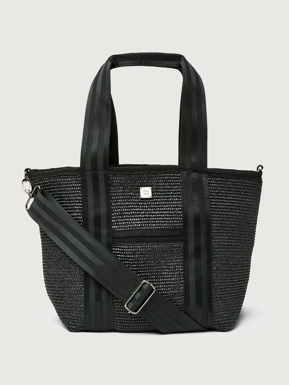 Close-up front angle of Think Royln Capri black tote with striped webbing straps and adjustable shoulder strap.