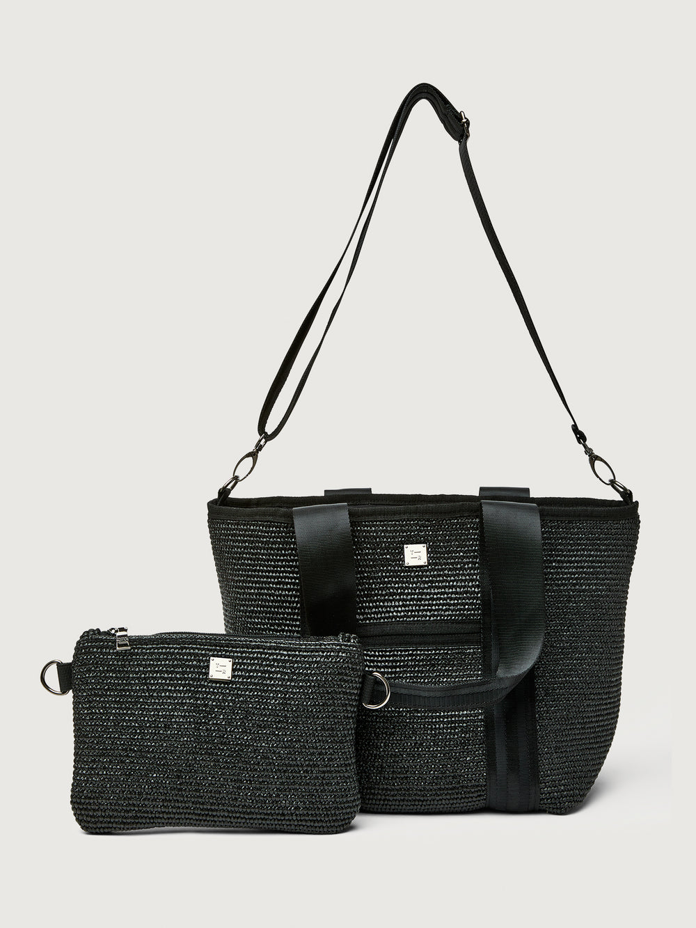 Back view of Think Royln Capri black tote with long crossbody strap and detachable black pouch.
