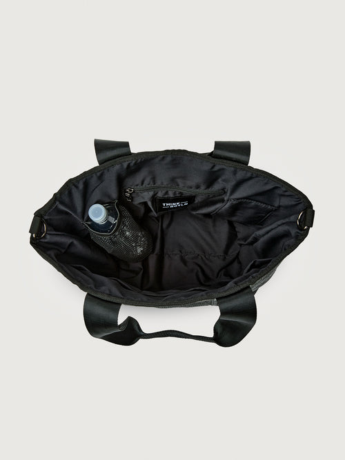 Interior view of Think Royln Capri black tote showing spacious lining, zip pocket, and side bottle holder.