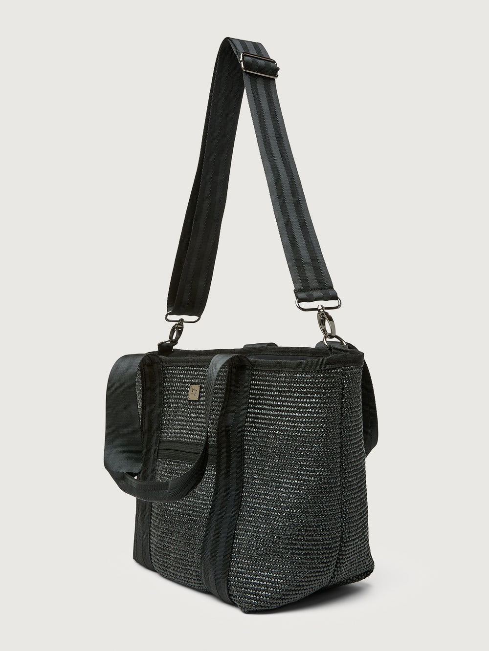 Three-quarter back view of Think Royln Capri tote in black with wide crossbody strap.