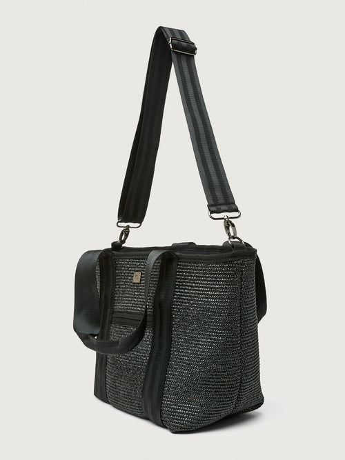 Three-quarter back view of Think Royln Capri tote in black with wide crossbody strap.