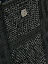 Close-up of Think Royln Capri woven black exterior with textured finish and silver logo plate.