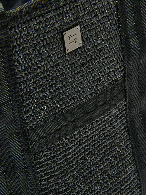Close-up of Think Royln Capri woven black exterior with textured finish and silver logo plate.