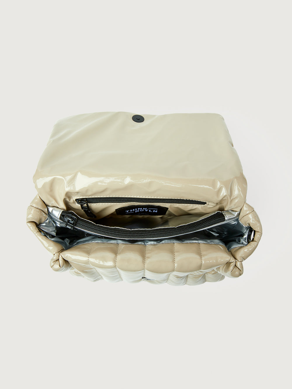 Beige handbag with black handle on a light gray background