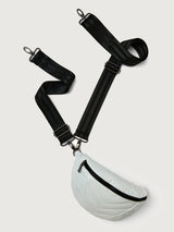 White patent leather bag with black hardware, featuring a half moon shape.