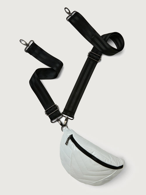 White patent leather bag with black hardware, featuring a half moon shape.