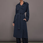 Model is wearing Elva Trench Coat in Navy, full body front view with belt tie.