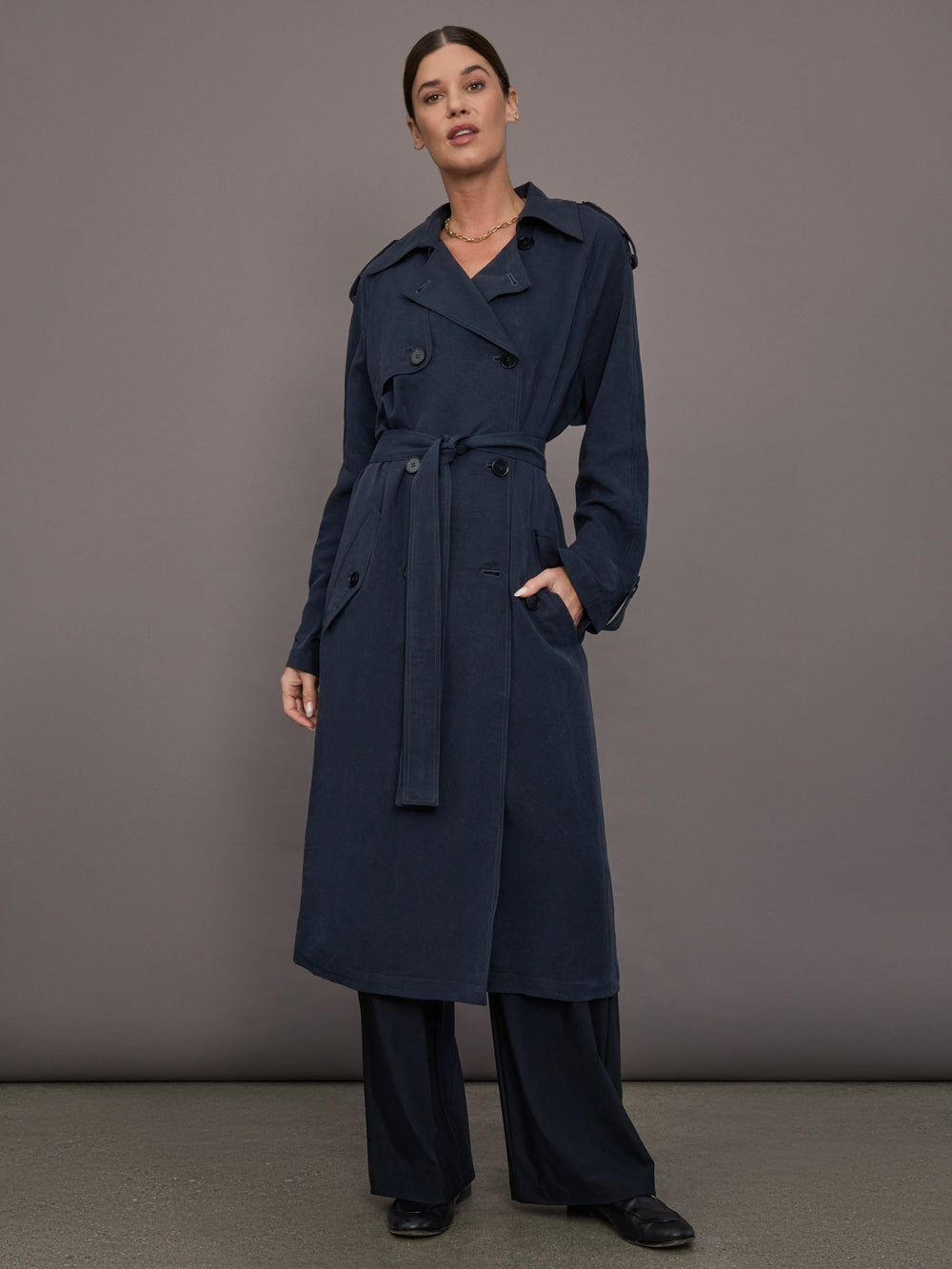 Model is wearing Elva Trench Coat in Navy, full body front view with belt tie.
