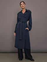 Model is wearing Elva Trench Coat in Navy, full body front view with belt tie.