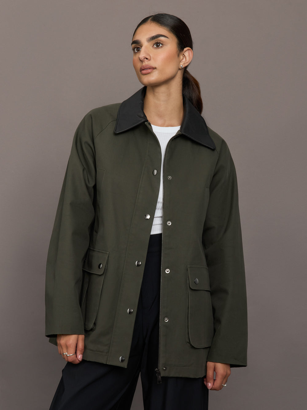 Model is wearing the utility barn jacket in dark olive, front view.