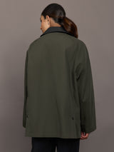 Model is wearing the utility barn jacket in dark olive, back view.
