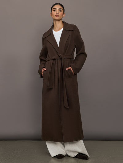 Model is wearing the belted maxi coat in brown, front view.