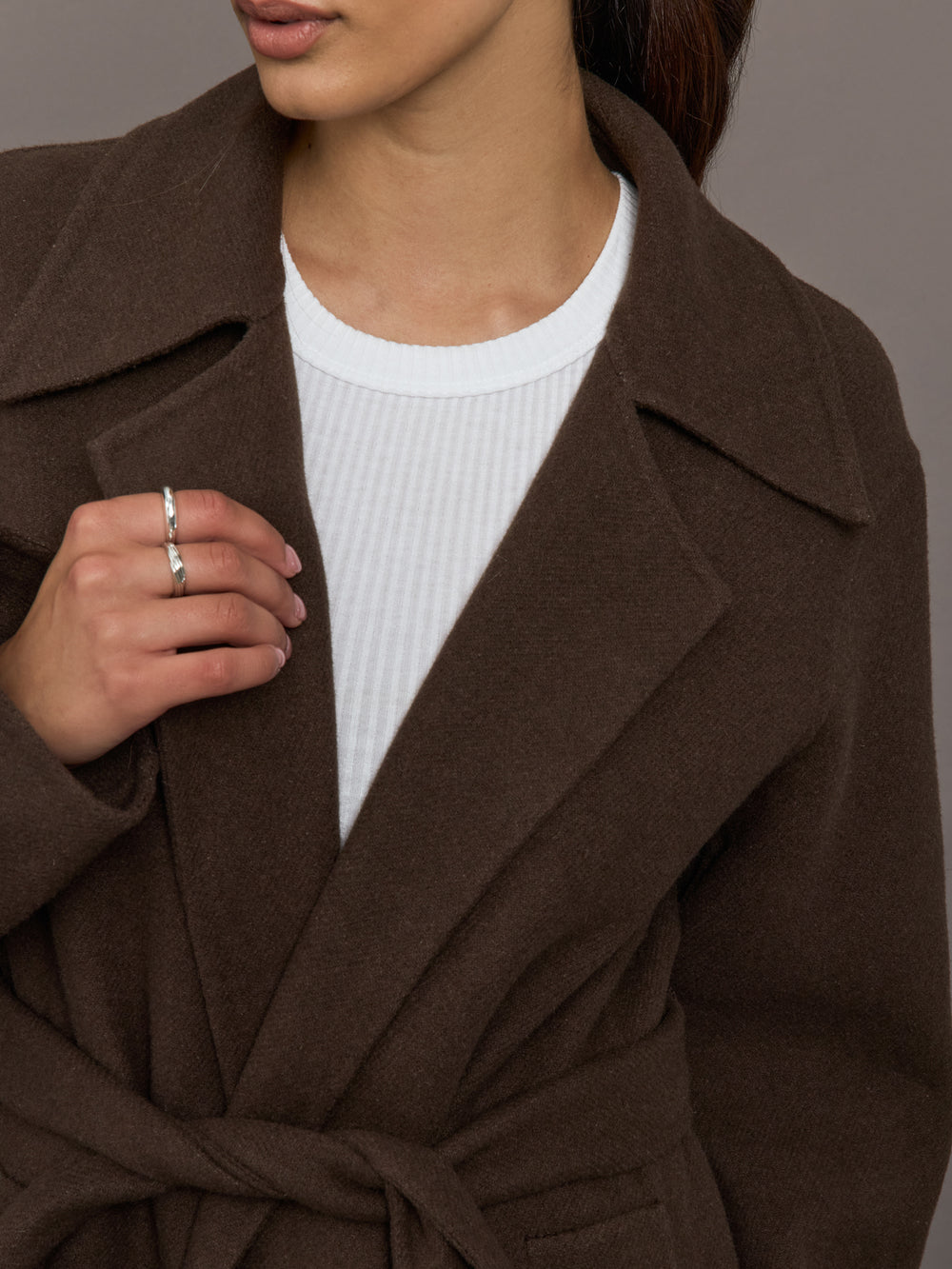 Close up of the belted maxi coat in brown, lapel and texture detail.