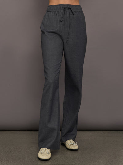 Model is wearing the relaxed drawstring pant in grey, front view.