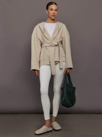 Model is wearing the Lyndi Hoody Coat in Creme, full body front view with leggings.