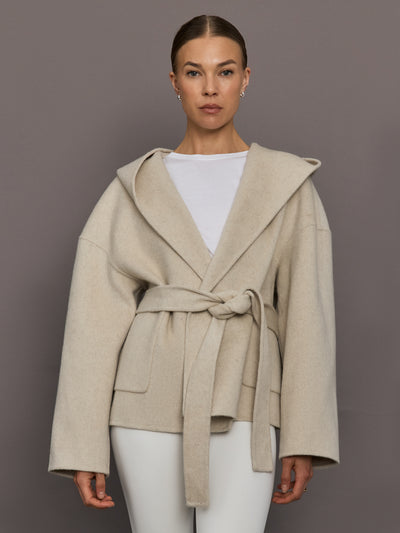 Model is wearing the Lyndi Hoody Coat in Creme, front view with tied belt.