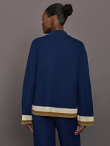 Model is wearing the Abigail Knit Shirt in Atlantic Stripe, back view showing relaxed fit and striped hem.