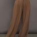 Model is wearing the Coconut cupro pleated wide leg pant, front view.
